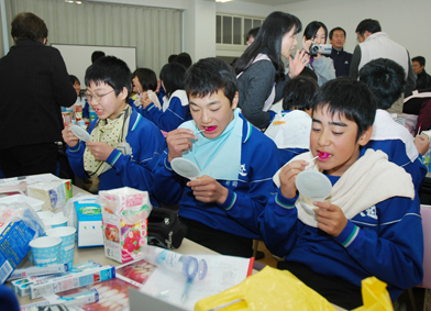 染色剤を歯につけて正しい磨き方を練習する生徒たち