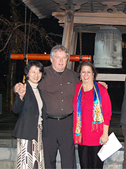 国連チャーチセンター中庭にある「平和の鐘」前で記念撮影に応じる塩飽さん。右が「アートマイル」を発案したジョアン・タウフィリス氏