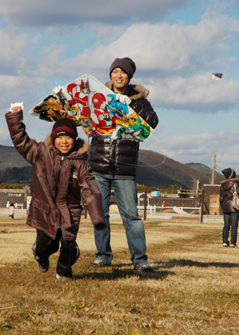 寒風の中、元気に凧あげを楽しむ親子