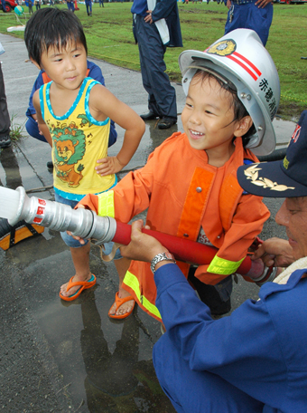 消防服を着て放水体験する子どもたち