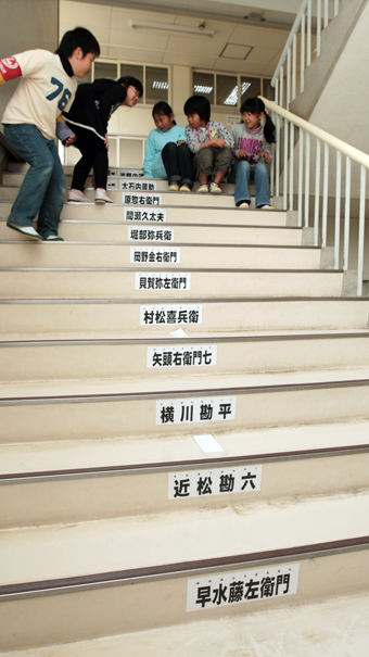 階段に貼り付けられたプレートで義士人名の暗記にチャレンジしている尾崎小児童