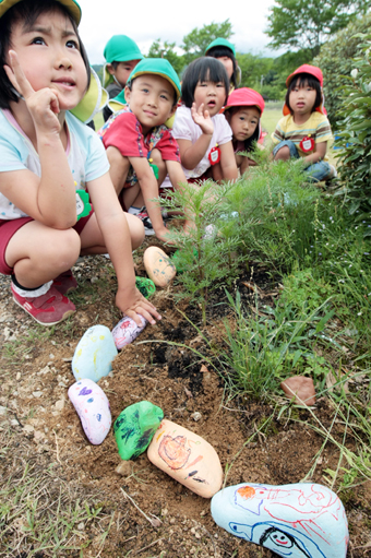 球根が植わっている周りにペイント石を並べる子どもたち