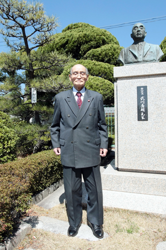 武川寿輔・初代校長を敬愛してやまなかった植木さんは赤穂高正門内に建つ胸像を訪ねることが多かった。左奥のマツは校舎移転時に自宅庭から移植したもの