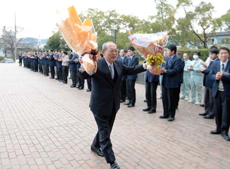 両手の花束を高々と掲げながら初登庁した豆田正明市長
