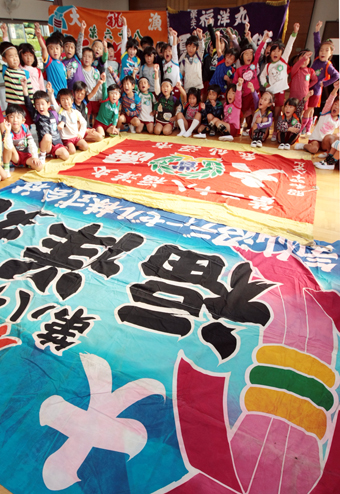 被災地から送られた大漁旗へ向かって「がんばろう日本！」と声を合わせた子どもたち＝塩屋幼稚園