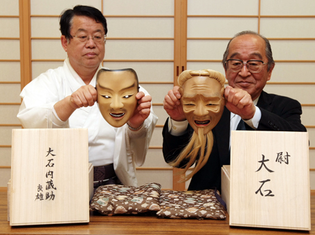 新作能「大石」の初公演で使われる面を改める江崎金治郎さん(右)と飯尾義明宮司