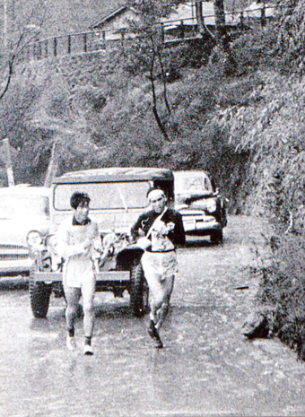 第３４回大会で５区の山上りを走る田中豊さん(右)。左側を走っているのは当時は認められていた伴走者＝田中さん提供