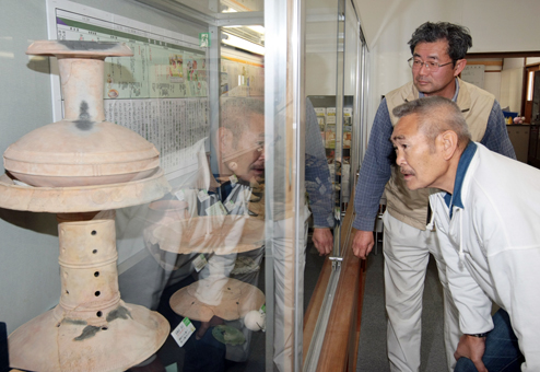 有年考古館で展示品をじっくりと観察する俳優の苅谷俊介さん。奥は宮崎素一館長