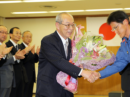 花束を手に笑顔で市長を退任した豆田正明氏