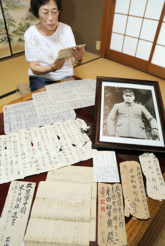 仏壇から見つかった手紙を見ながら父と兄の思い出を語る山崎久美さん