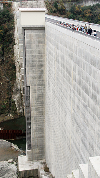 高さ６０メートルを超える金出地ダムの天端に上がって見学するツアー参加者