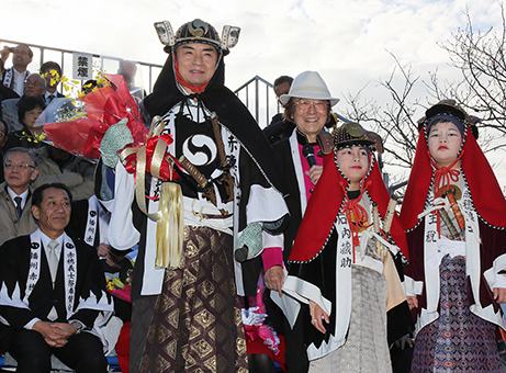 こども義士行列の出演者から花束を贈られた西郷輝彦さん。その右はパレードを実況した浜村淳さん