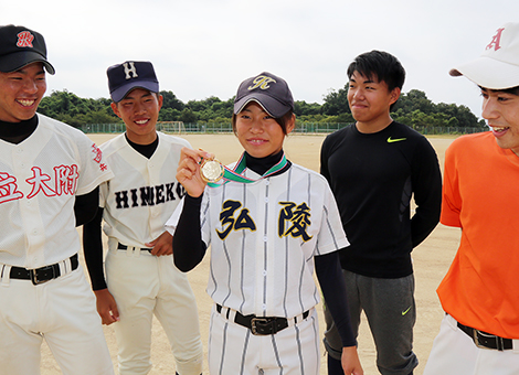 中学時代の野球部のチームメートに優勝メダルを見せる高田理緒さん