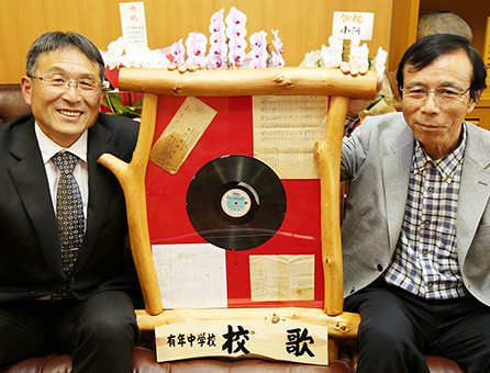 有年中校歌作詞者の池本一一氏が遺したレコード原板を寄贈する長男芳文さん(右)