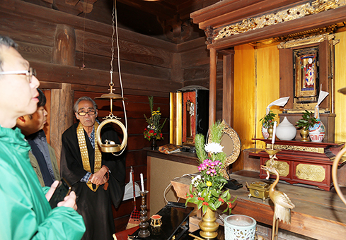 地元で「秘仏」とされてきた太子像を調査する金子哲教授(左)