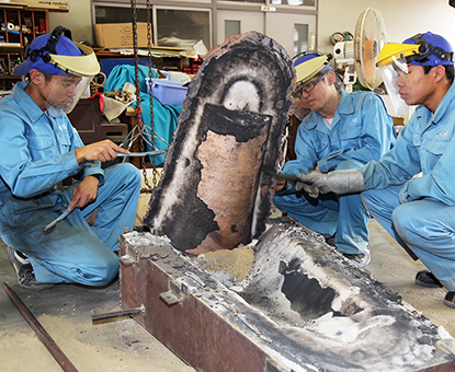 鋳型から取り出した銅鐸をブラシで磨く相生産機械科の生徒たち