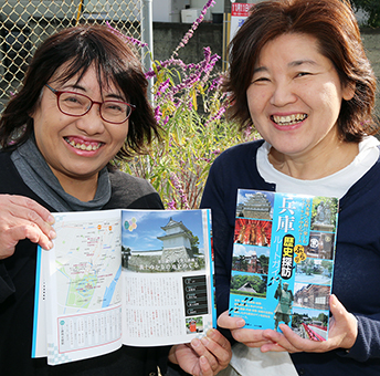 「兵庫ぶらり歴史探訪ルートガイド」を手にする磯本さん(左)と益田さん