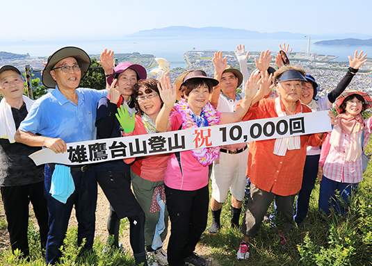 雄鷹台山で初の通算１万日登山を達成し、仲間から祝福される常念初恵さん＝中央