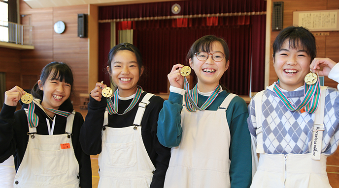 地元住民から贈られたメダルを手に笑顔を見せる有年小６年女子リレーメンバーの＝左から＝山本陽葵（ひまり）さん、井上実玲（みれい）さん、村上結心花（ゆみか）さん、桑原碧彩（あおい）さん