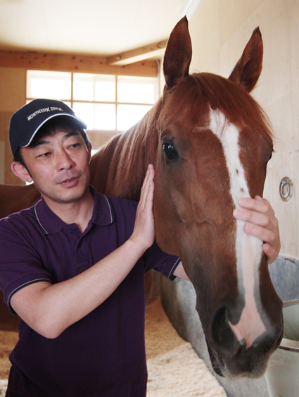 殊勲のアドマイヤジュピタをいたわる友道さん