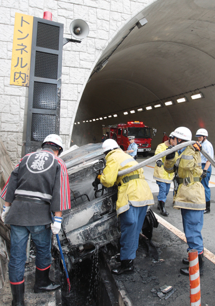 炎上した車を消火する消防隊員
