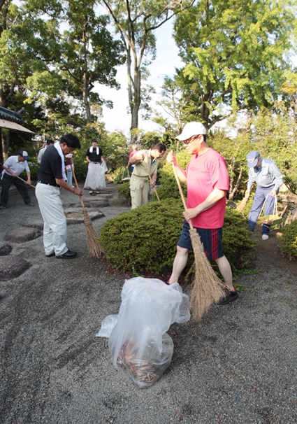 早朝に清掃奉仕するロータリー会員=大石神社庭園