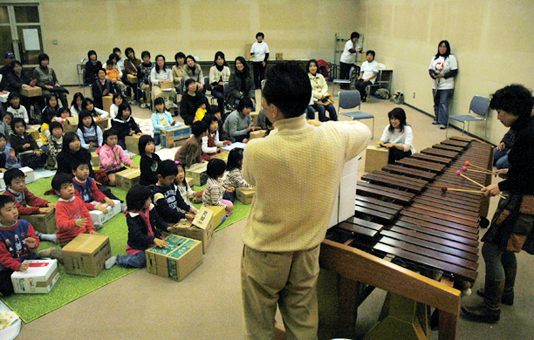 マリンバに合わせて段ボール箱を打ち鳴らす子どもたち