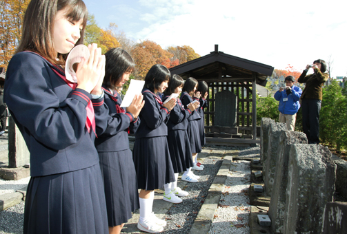 修学旅行で訪れた北泉岳寺で義士の墓に手を合わせた赤穂中生徒
