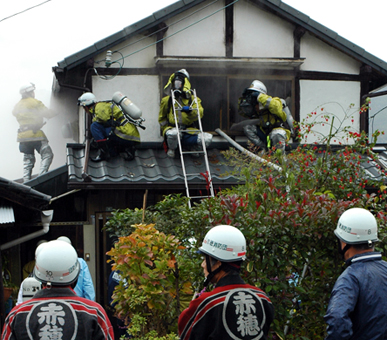 火災現場で鎮火を確かめる消防隊員