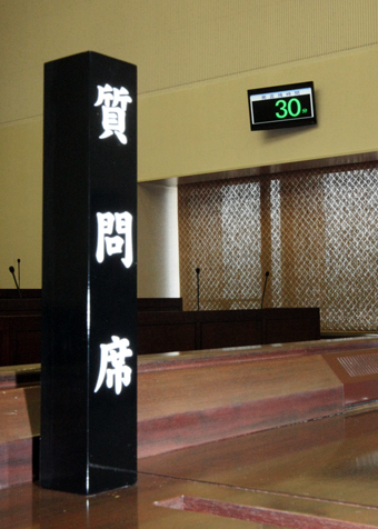 議場中央に設けられた質問席。奥のモニターに残り時間が表示される
