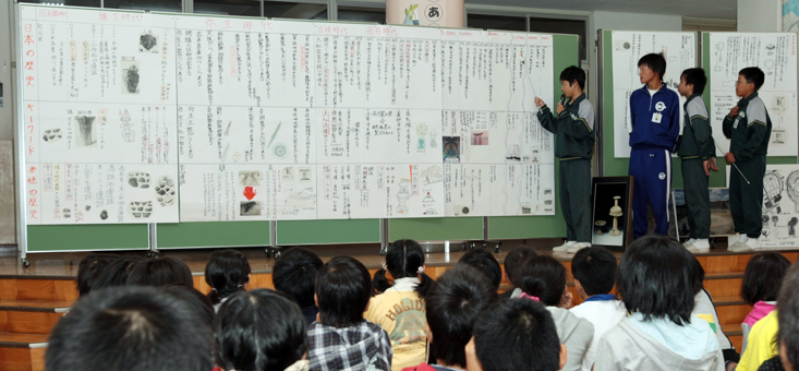 「博物館学芸員」として遺跡の調査研究結果を発表する中学生