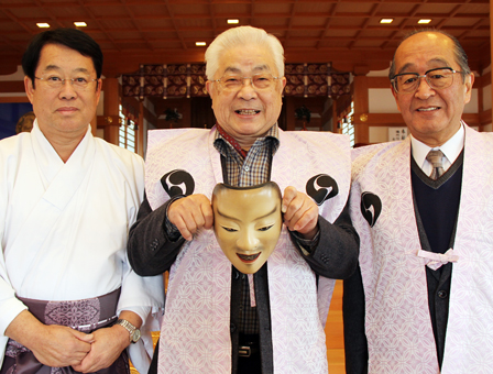 楠本能白さん(中)から能面奉納を受ける飯尾義明宮司。右は江崎金治郎さん