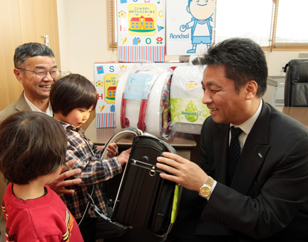 ランドセルを手渡す岩下信彦・あいおいニッセイ同和損害保険姫路支店長