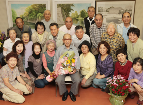 卒寿記念で回顧展を開いた米谷朝五郎さん=中央