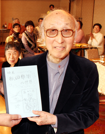 メンバーから長年の活動を称えられる秋田泰治さん