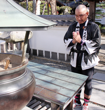 義士墓所で完走を報告する三遊亭楽松さん=花岳寺