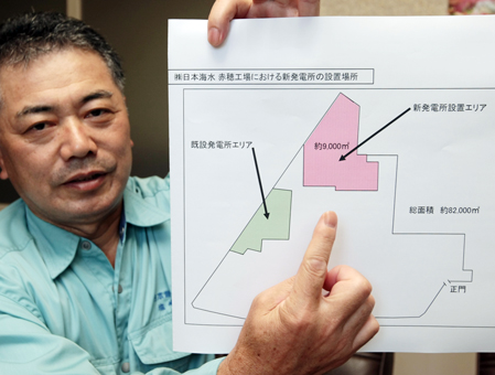 国内2番目の規模となる木質バイオマス発電設備の建設予定地を指し示す塩崎成治工場長