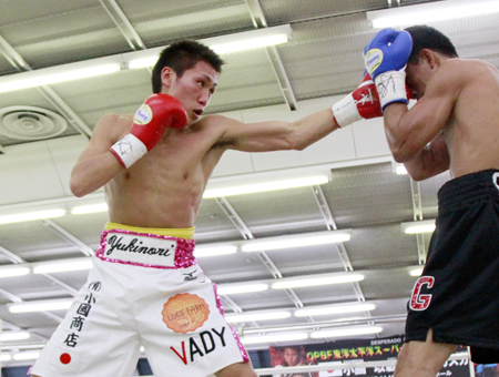 ジャブで挑戦者を攻撃するチャンピオン・小國