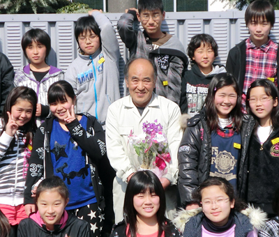 感謝の品を贈った卒業生たちと記念写真に収まる船津吉敬さん=保護者提供
