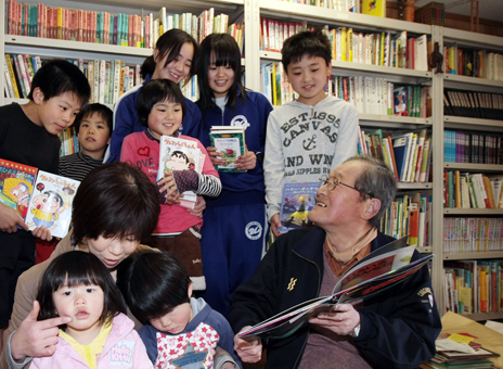 7カ月ぶりに私設図書館を再開し、子どもたちに絵本をすすめる久保良道さん(右)