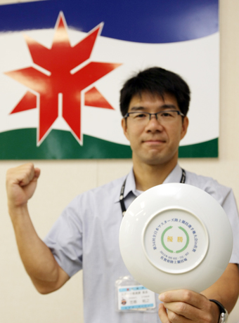 全日本マスターズ陸上で2度目の優勝を飾り、伊万里焼の優勝杯を手にガッツポーズの笠原裕之さん