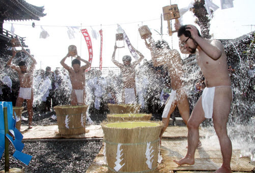 100日間の荒行を終え、奉告祭で冷水をかぶる修行僧たち=左から2人目が井本さん