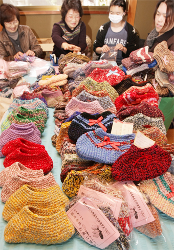 手編み靴下を袋詰めする「手編みホームカバーお届け隊」のみなさん