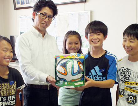 本田充局長から児童に手渡された「ブラズーカ」のレプリカ