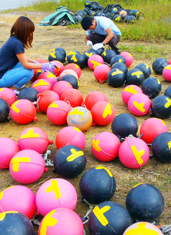 訪問先の南三陸町で漁業に必要なブイにペンキを塗る災害ボランティアサークル「KUSW〜絆〜」