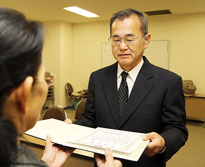 激戦から一夜明け、当選証書を受け取る明石元秀氏