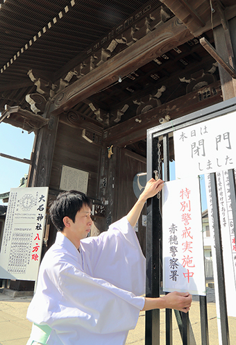 緊急対策会議で配られた防犯プレートを取り付ける文化財管理者