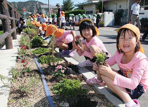 加里屋川沿いの花壇に花苗を植えた園児たち