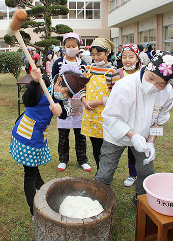 田植えから収穫まで行った米でもちをつく児童たち
