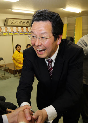 無投票で４選が決まり、支援者と笑顔で握手を交わす長岡壮壽氏
